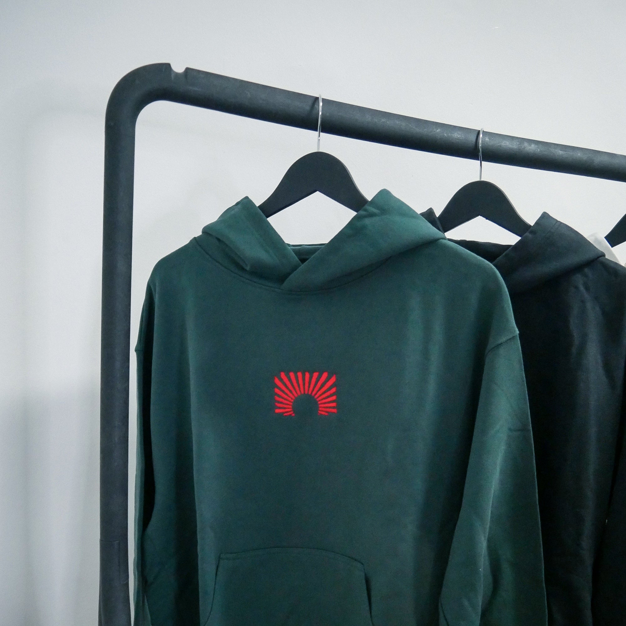 Gruene EARLYUP Hoodies an einer Kleiderstange